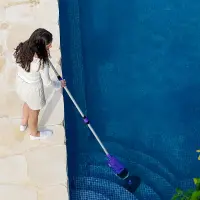 Nettoyage manuel des marches d'une piscine avec un balai aspirateur