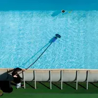 Nettoyage du fond d'une piscine hors-sol avec un balai aspirateur